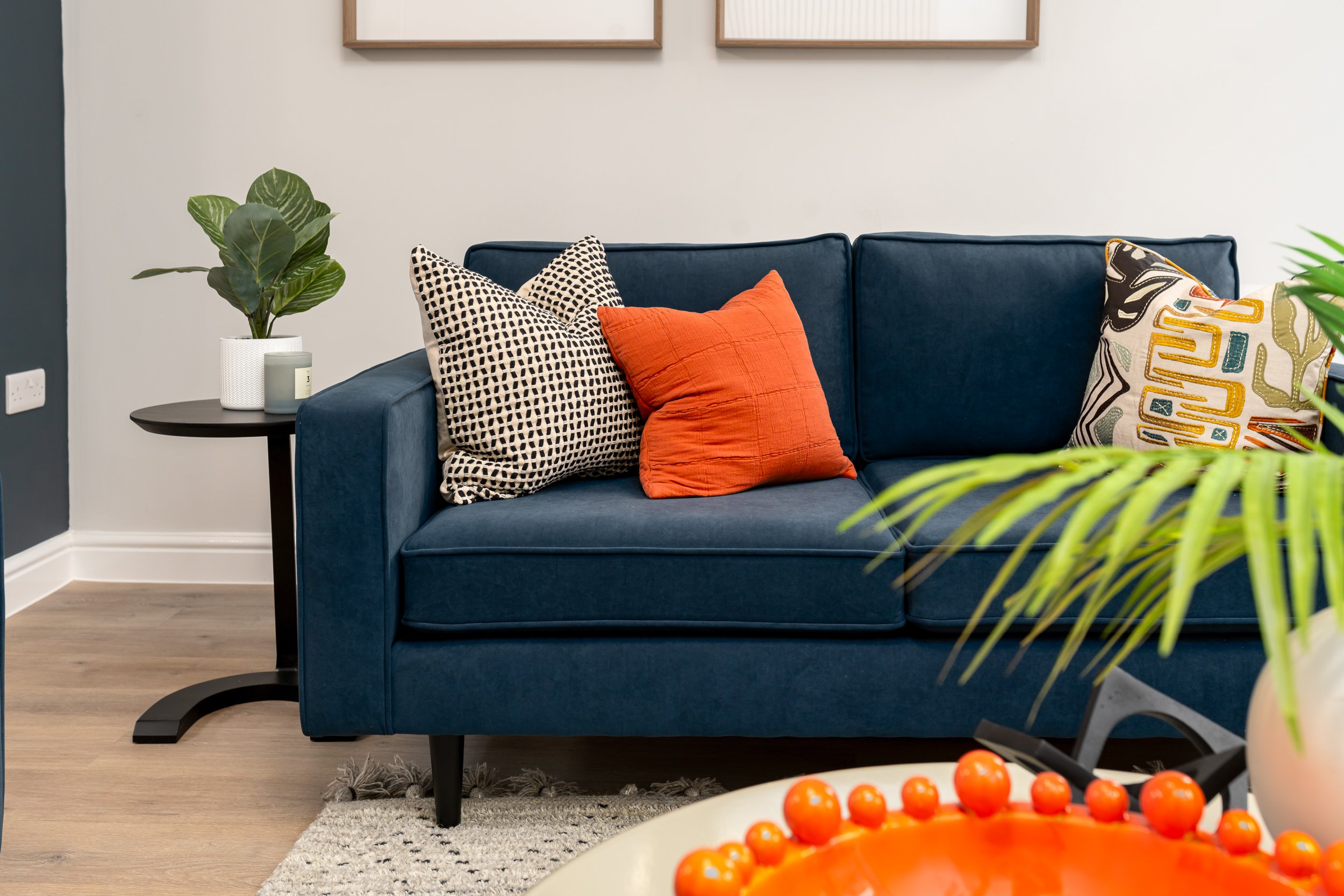close up of blue sofa with red cushion.