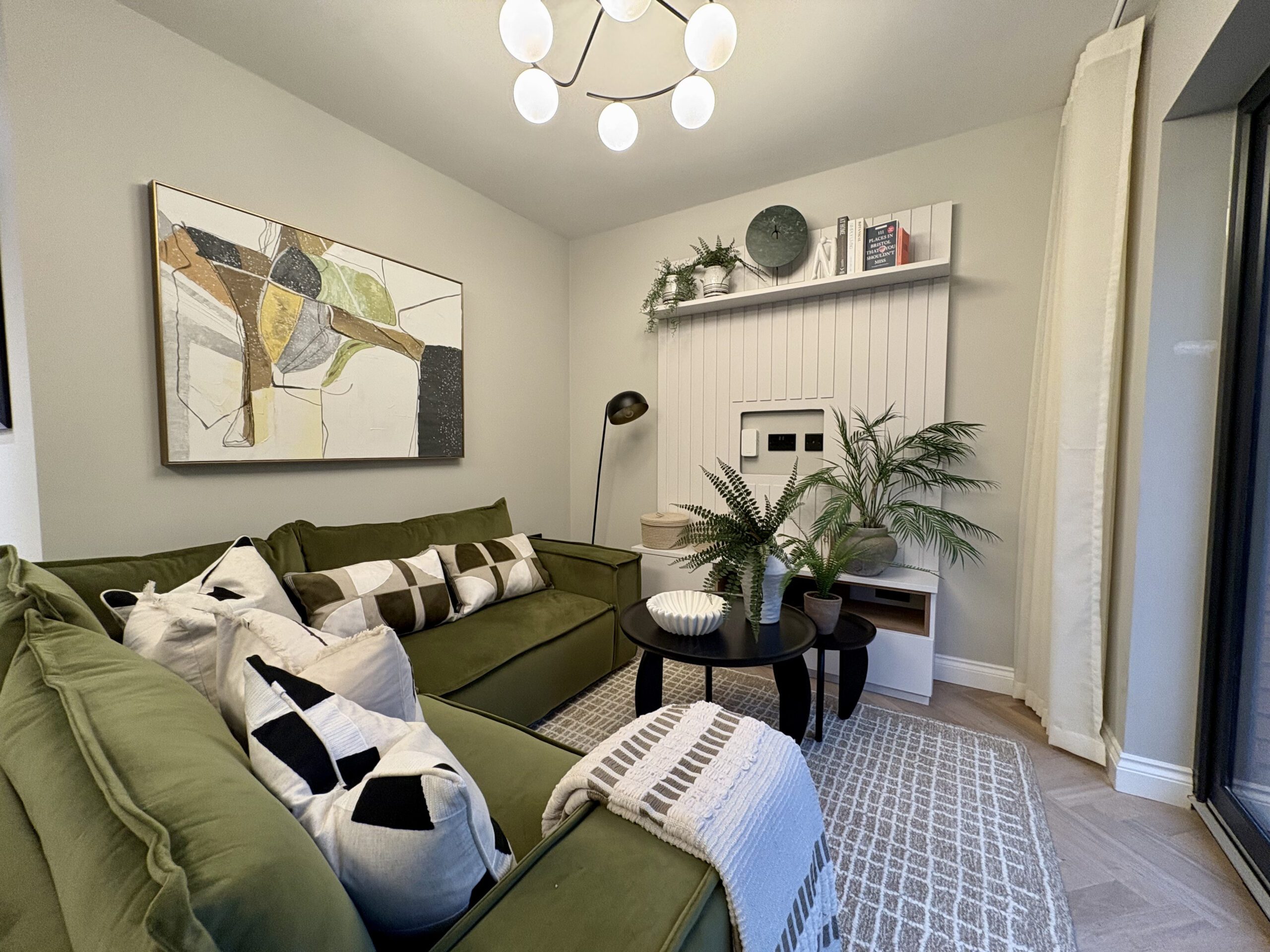 A living room featuring green furniture and a colourful painting on the wall, creating a vibrant and inviting atmosphere.