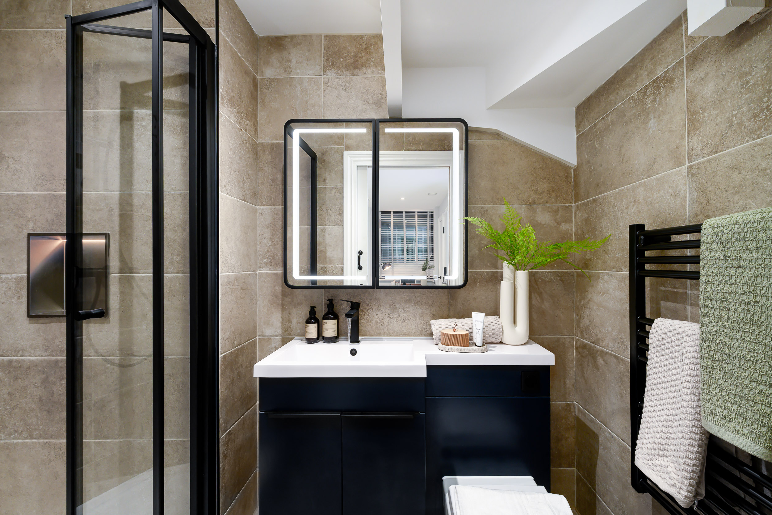 A bathroom featuring a sink, toilet, and shower, designed for functional and efficient use of space.