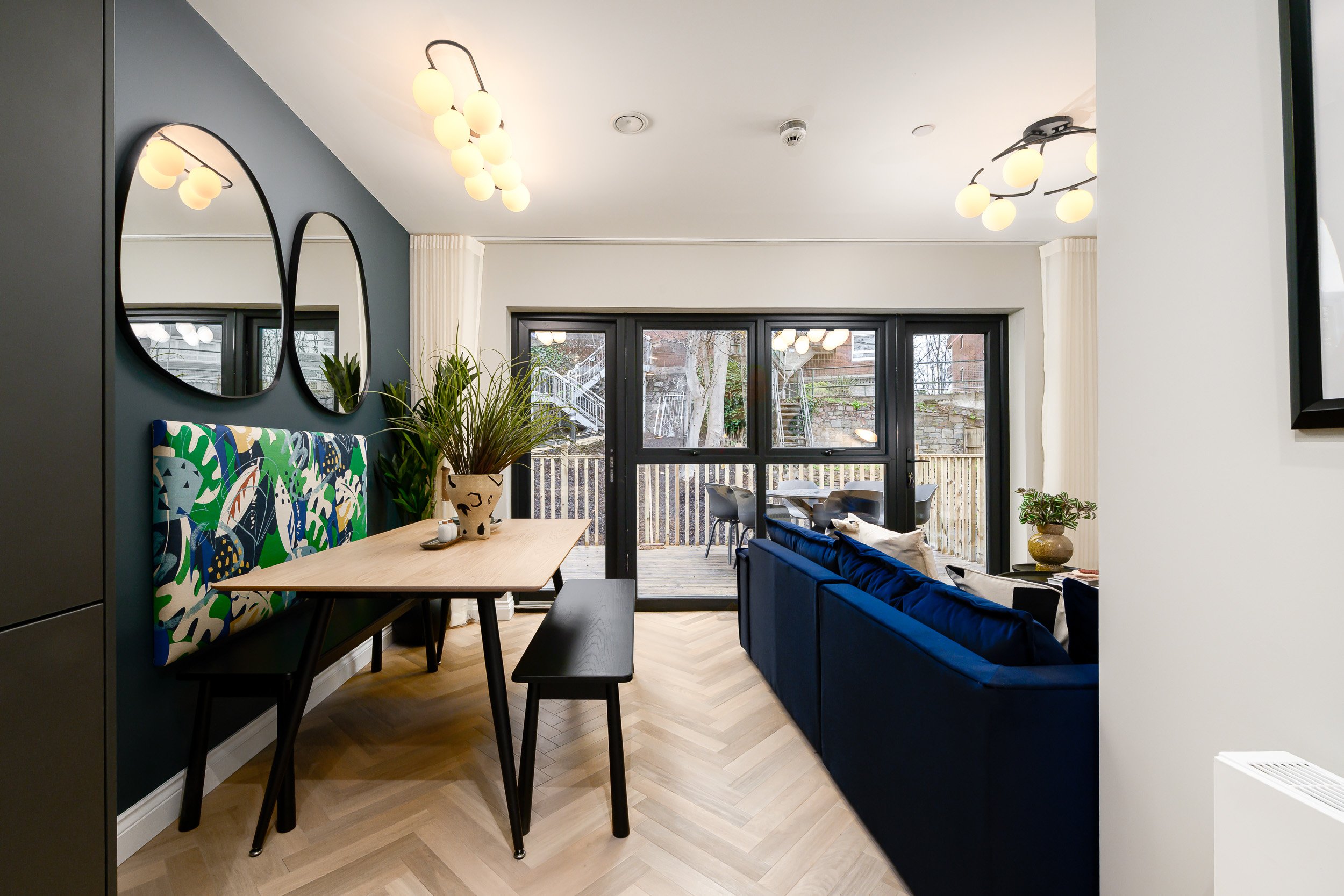 Interior of a modern apartment with blue furniture and a sleek dining table, highlighting a chic living space.